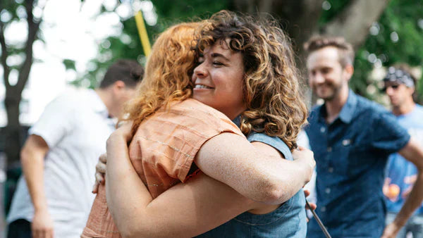 Two women hugging at an outdoor event