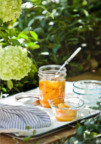 A jar of peaches on a tray outdoors