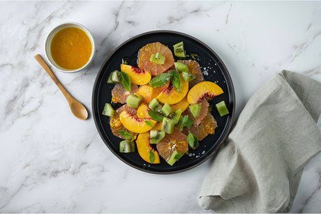 Peach, grapefruit, and kiwi salad on a marble countertop