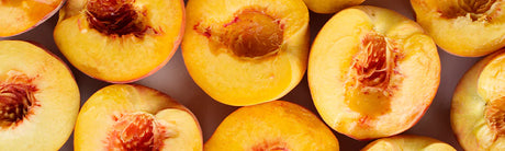 Banner showing sliced peaches with the pits in