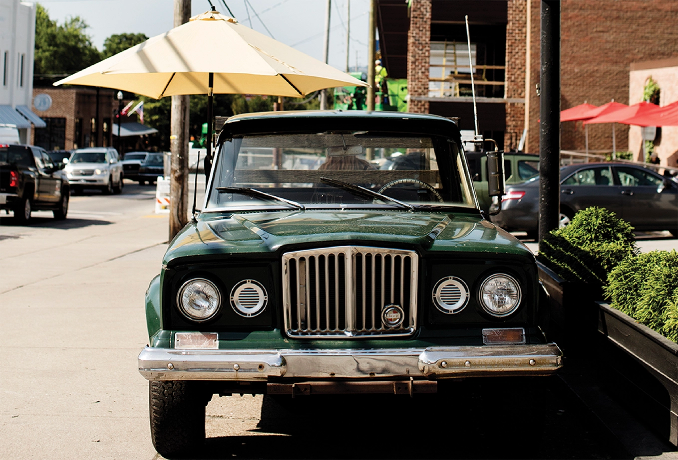 Old green truck parked on a downtown street