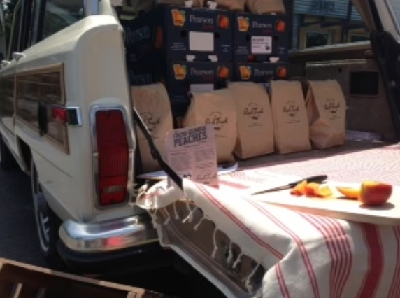 Peach produce and goods loaded into the back of a truck