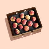 A carefully packed open box of peaches